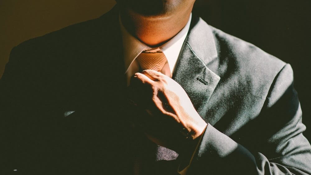 Man Tying Tie on Suit