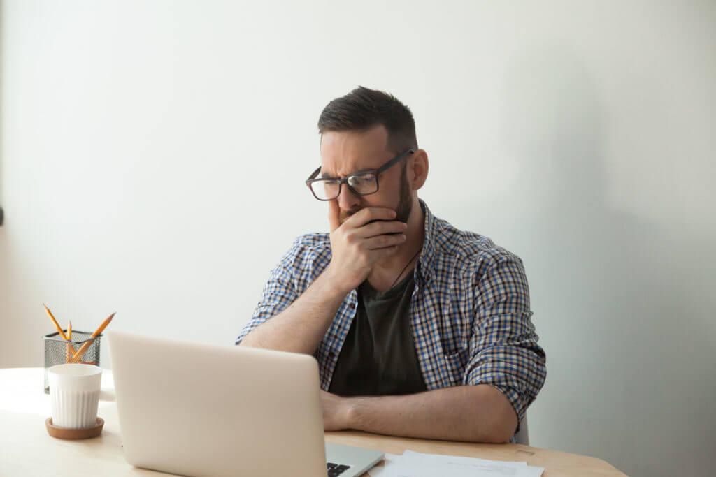 Man reading computer upset