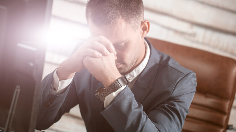 Man Praying at Desk