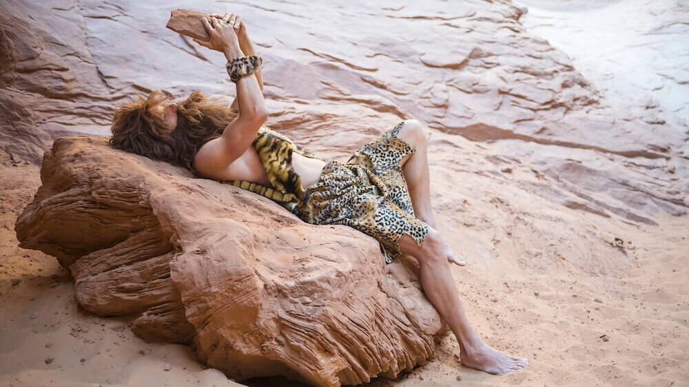 Caveman reading stone tablet