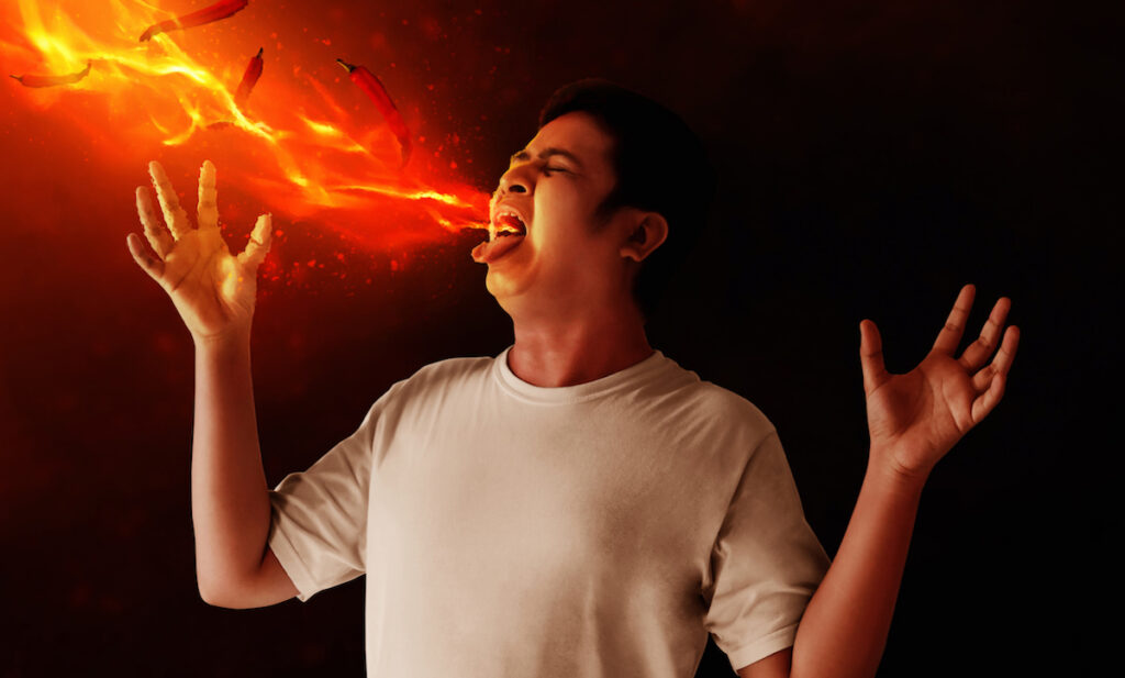 Man breathing fire after eating something hot